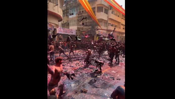 People throw clothes covered in red coloring in Kanpur, India
