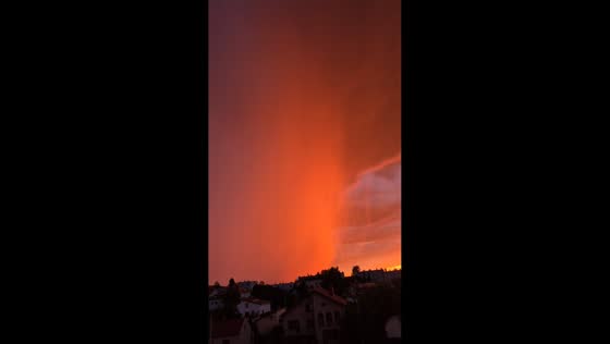 Fiery sunset illuminates approaching storm over Kielce, Poland