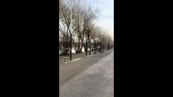 Retired lady balances on workout bar during morning routine in Jilin, China