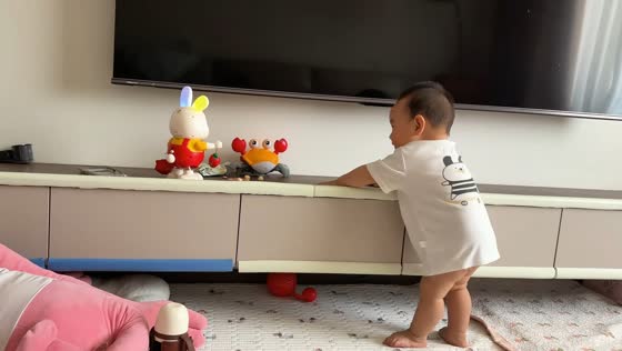 Baby dances along with moving rabbit toy in Henan, China