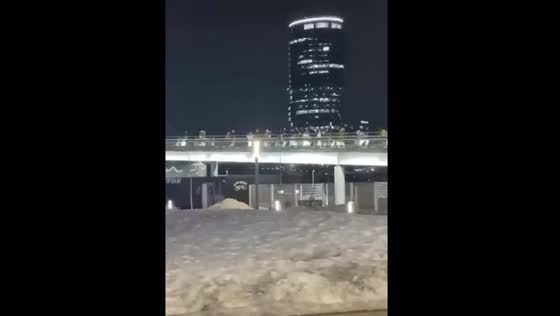 Hundreds of people run across the bridge from the Crocus building after a terrorist attack in Moscow