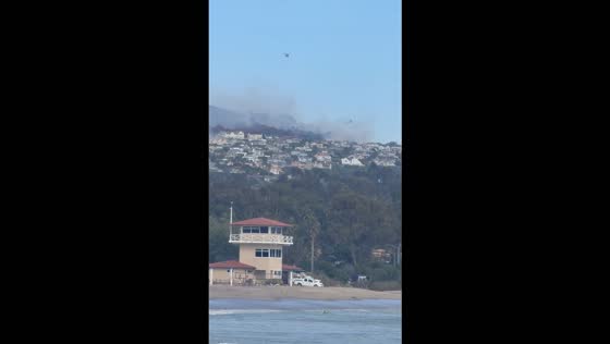 CH-47 Chinook helicopter battles Norte Fire as smoke rises along the California coast, USA