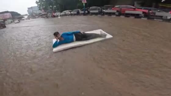 Person enjoys floating on foam in Pune flood waters