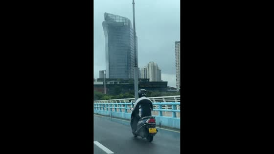 Man’s jacket flaps like dance moves on motorcycle in Fujian, China