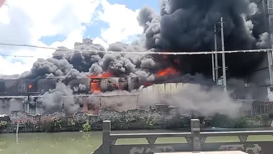 Massive fire sends thick smoke across river in Zhejiang, China