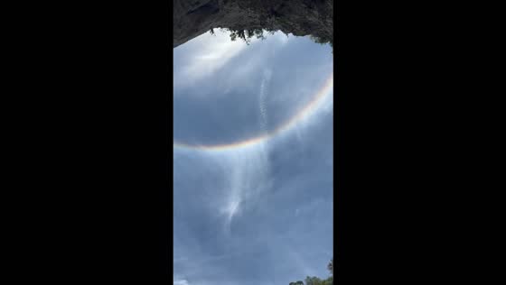 Rainbow-like arc frames a waterfall at Casa de Pedra Cave in Iporanga, Brazil