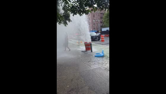Children play under fire hydrant waterfall in New York City, New York, USA