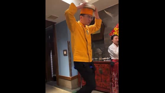 Person balances on unicycle while cutting noodle dough with head