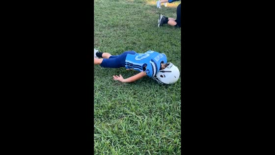 Boy fixes push-up form during football practice in Stanley, North Carolina