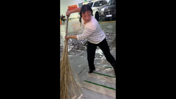 Workers clear muddy floodwater from building in Jiangsu, China