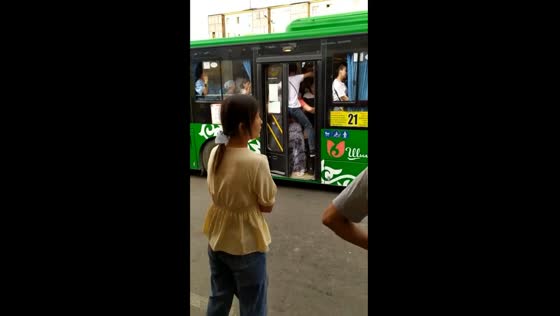 Overcrowded bus in Shymkent, Kazakhstan: man struggles to board