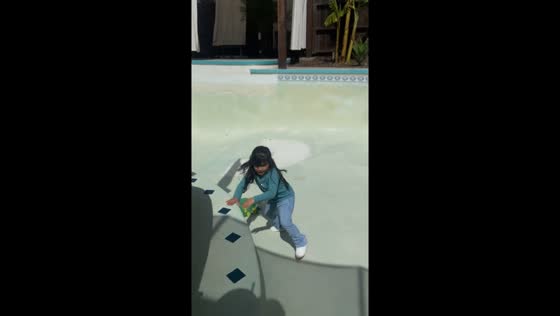 Little girl scared of “sharks” in empty pool in Fresno, California, USA