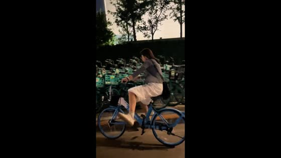 Woman loses balance and crashes into parked bicycles in Beijing, China