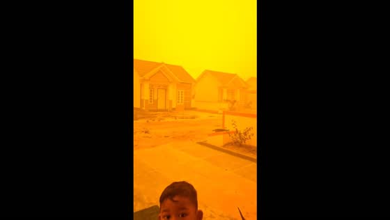 Thick orange haze blankets a residential area amid forest and land fires in Palangkaraya, Indonesia