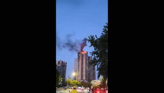 Fire engulfs top of high-rise residential building in Qinhuangdao, China