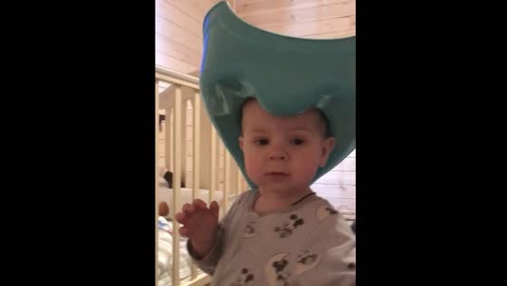 Funny toddler wears a toilet seat on his head like a cowboy hat!