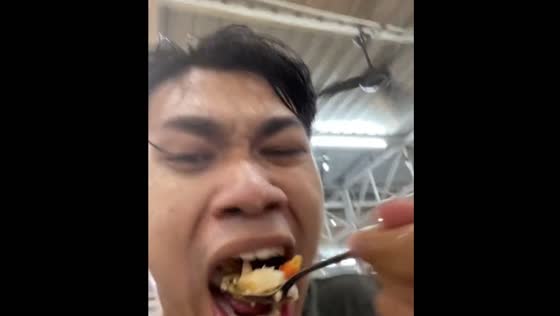 Man continues eating during heavy rain in Melaka, Malaysia