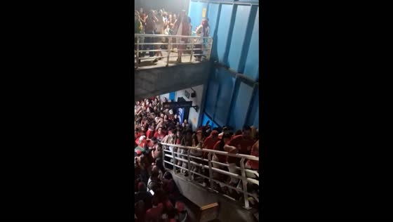 Large crowd chants while walking through Cantagalo subway station in Rio de Janeiro, Brazil