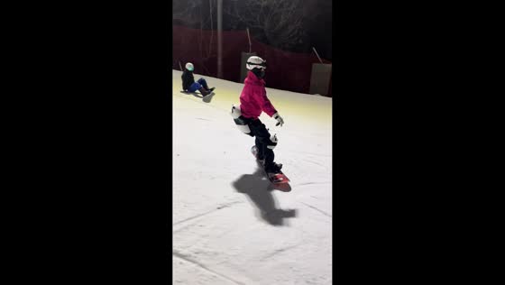 Woman skis steadily as another skier crashes beside her in Shandong, China