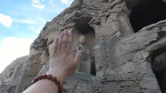 Tourists share playful "high-fives" at the Yungang Grottoes in Datong, Shanxi, China