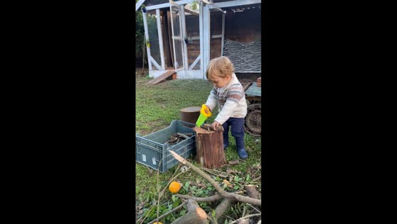 Toddler playfully pretends to saw wood in Sapucaia do Sul, Brazil