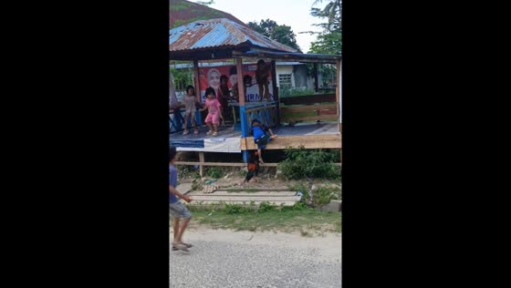 Children in Indonesia run from rooster chasing them