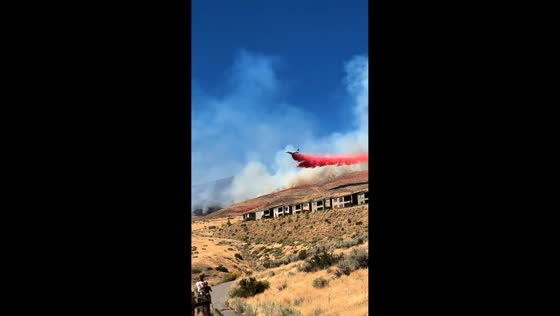 Firefighting aircraft drops retardant over massive wildfire near Reno, USA