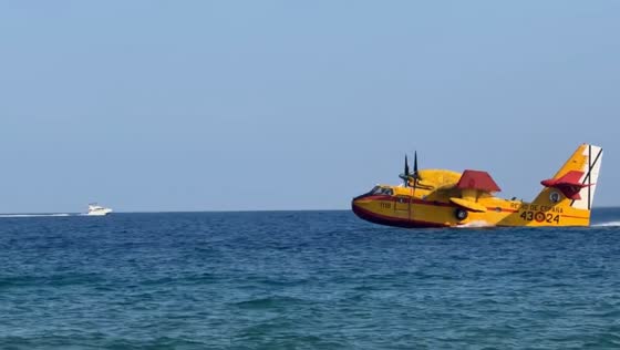 Firefighting plane scoops seawater off Ocata Beach in Catalonia, Spain