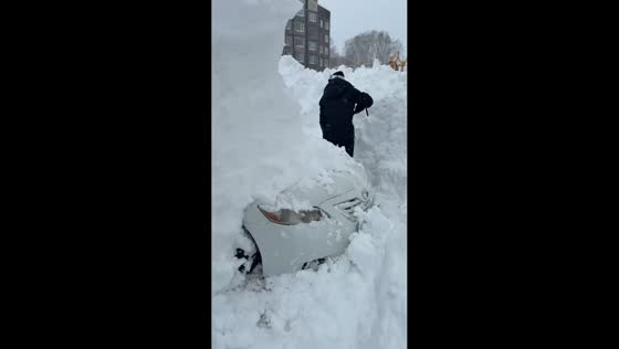 Man digs out car after overnight snowfall in Kamchatka, Russia