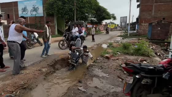 Motorcyclist loses balance while navigating muddy road in Giridih, India