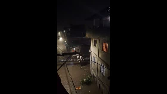 Residents take shelter on beam above rising flood in Fairview, Quezon City, Philippines
