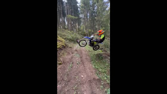 Enduro rider loses balance and crashes after jumping onto a forest trail in France