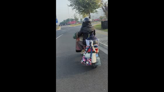Grandma rides scooter with puppy in Jiangsu, China