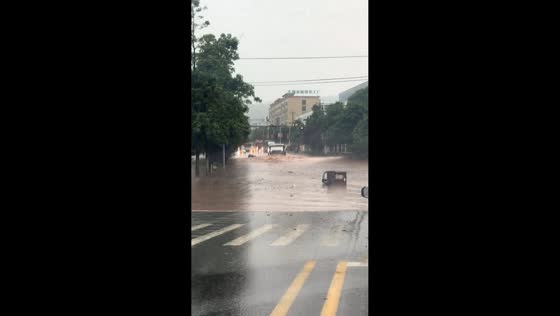 Flooded road in Chongqing as vehicles navigate rising waters during heavy rain in China