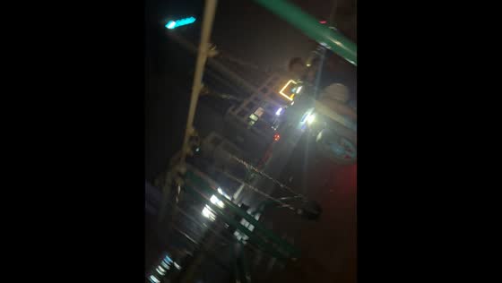Man rides e-bike on swing at playground at night in Henan, China