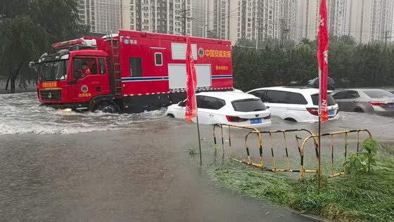 Floodwaters rock parked cars as fire truck passes in Shenyang, China