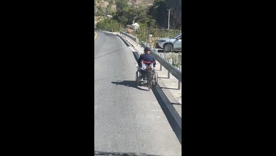 Dog helps push a man in a wheelchair in Sichuan, China 