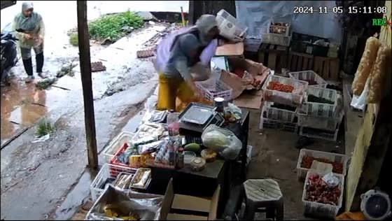 Two women startled by thunder at fruit store in Tangerang, Indonesia