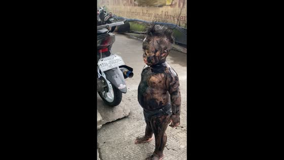 Child dressed in unique black oil costume for Halloween in Manila, Philippines