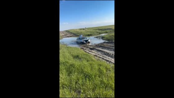 Car gets stuck in large puddle and towed out in Manitoba, Canada