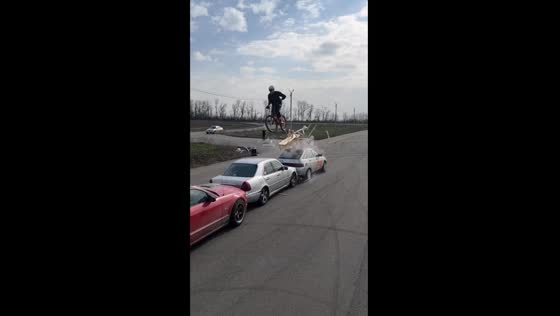 Thrilling stunt: daredevil biker defies gravity as three cars topple wooden structure!