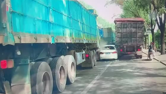 Car trapped between two trucks during risky lane change in Shanxi, China