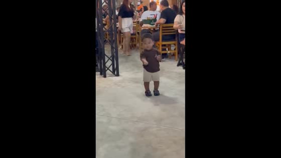 Young boy dances and drums in restaurant in Brazil