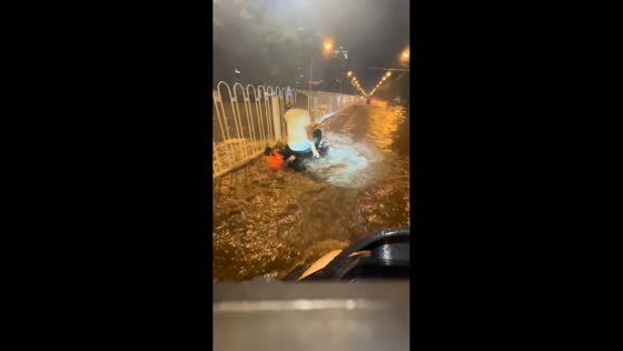 E-bike rider falls after hitting uneven road in flooded street in Hebei, China