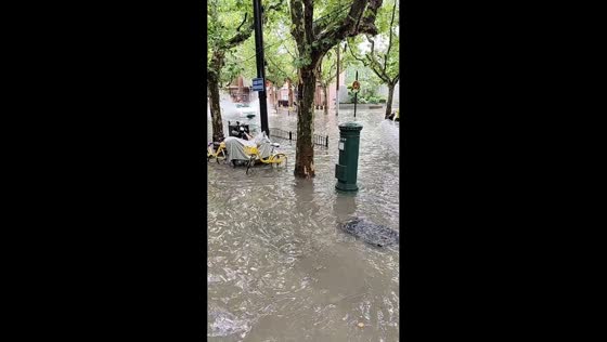 Car drives through flooded street and creates large splashes in Shanghai, China