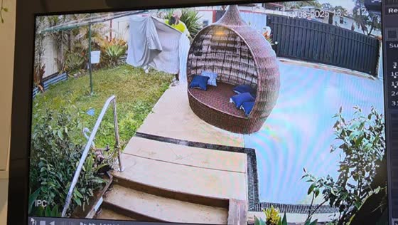 Delivery man protects parcel and sheets from rain in Kingston, Queensland