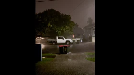 Trash bin swept away in Brisbane rain after collision with another bin