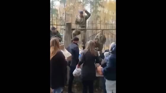 Relatives and friends of the mobilized give them things, food and hot tea through the fence