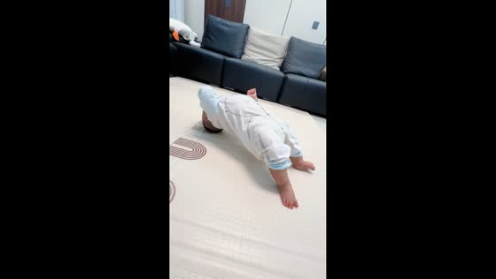 Toddler scoots across floor after playful bridge pose in Shandong, China
