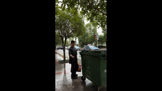 Man throws garbage bag into trash can in unusual way in Anhua, Hunan, China
